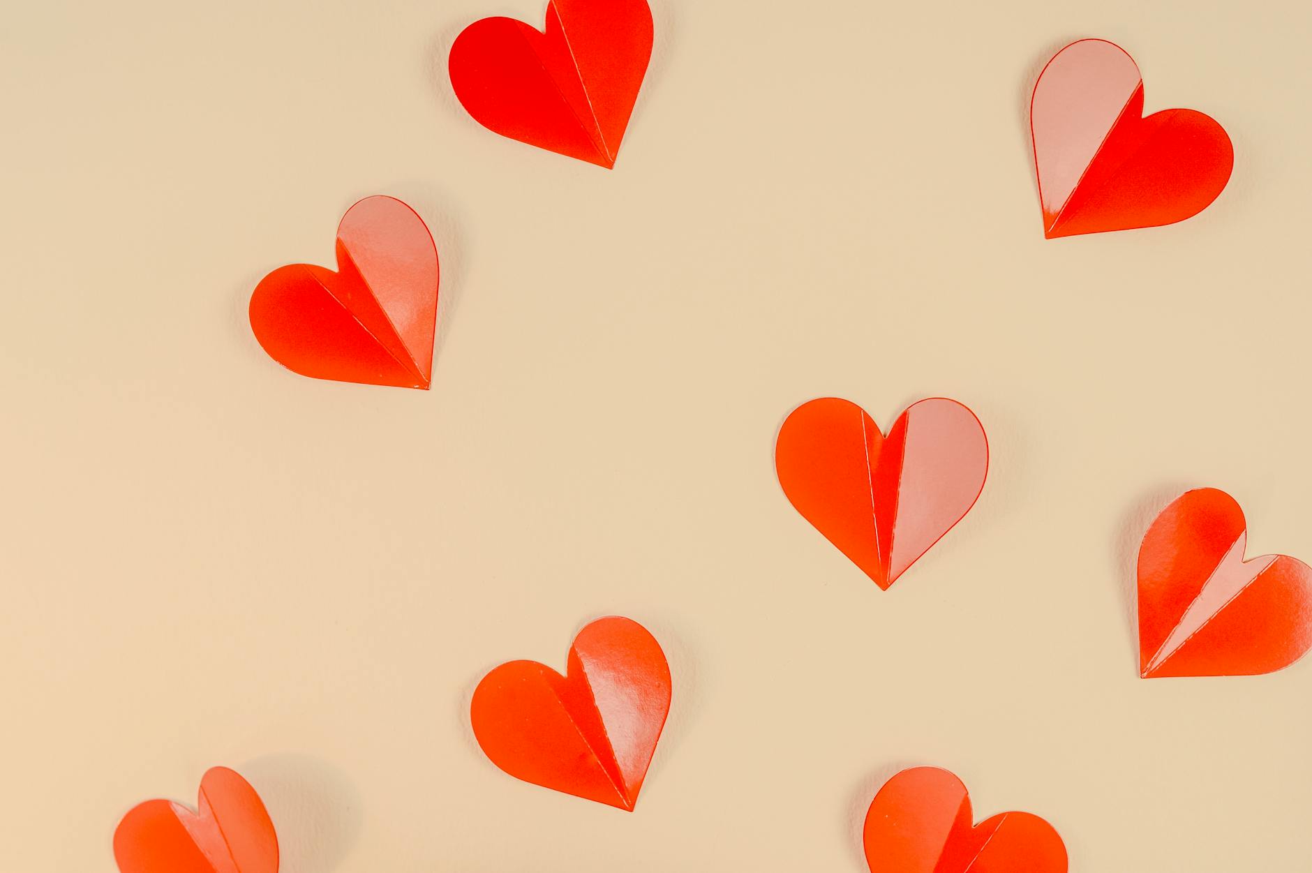 Artystyczna kompozycja czerwonych papierowych serc na jasnym tle