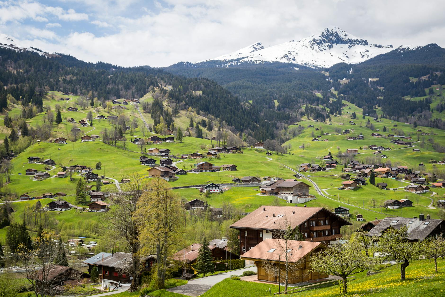 Alpejska wioska Interlaken otoczona zielonymi wzgórzami i ośnieżonymi szczytami