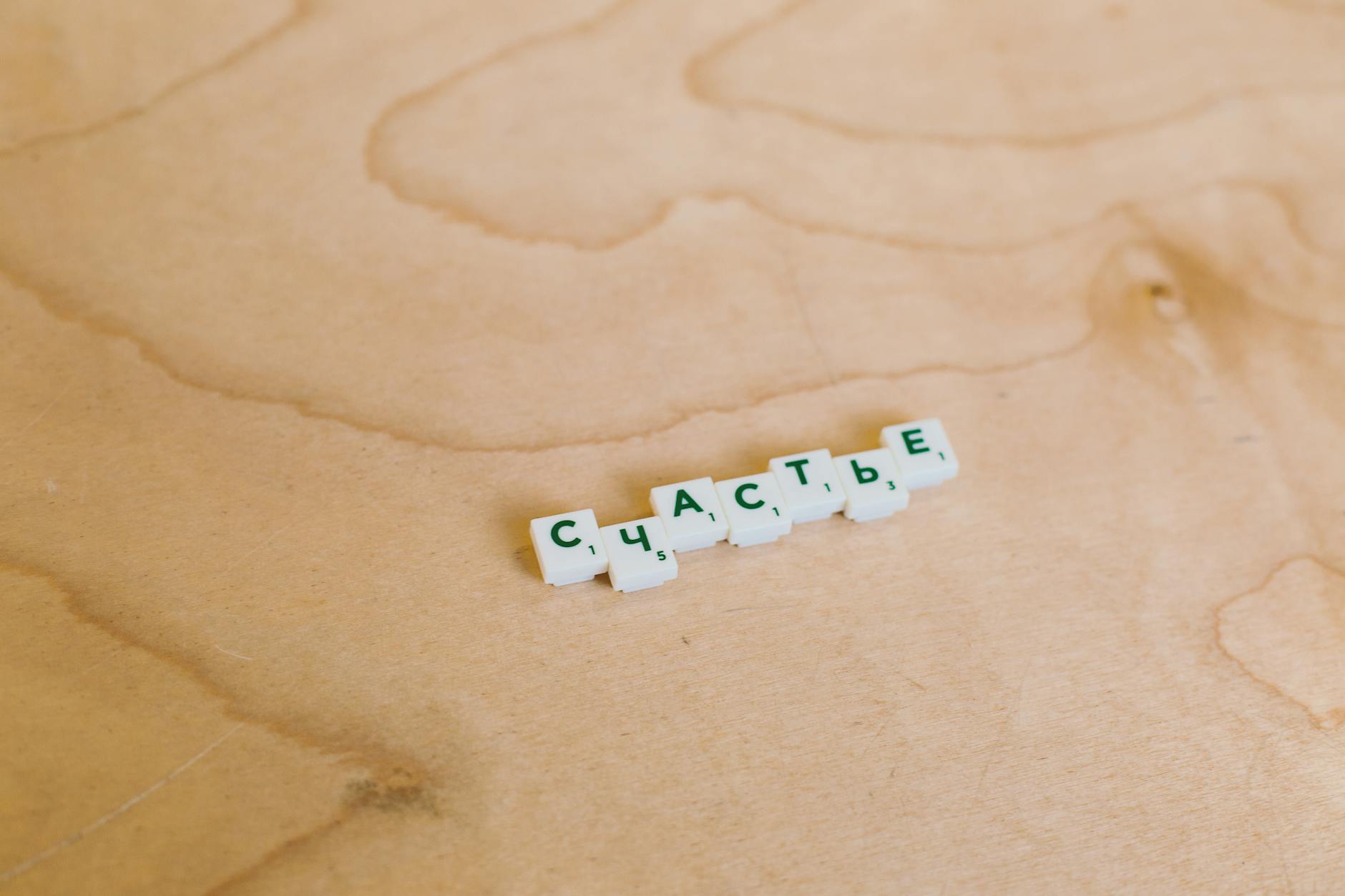 Drewniane płytki Scrabble układające rosyjskie słowo na blacie