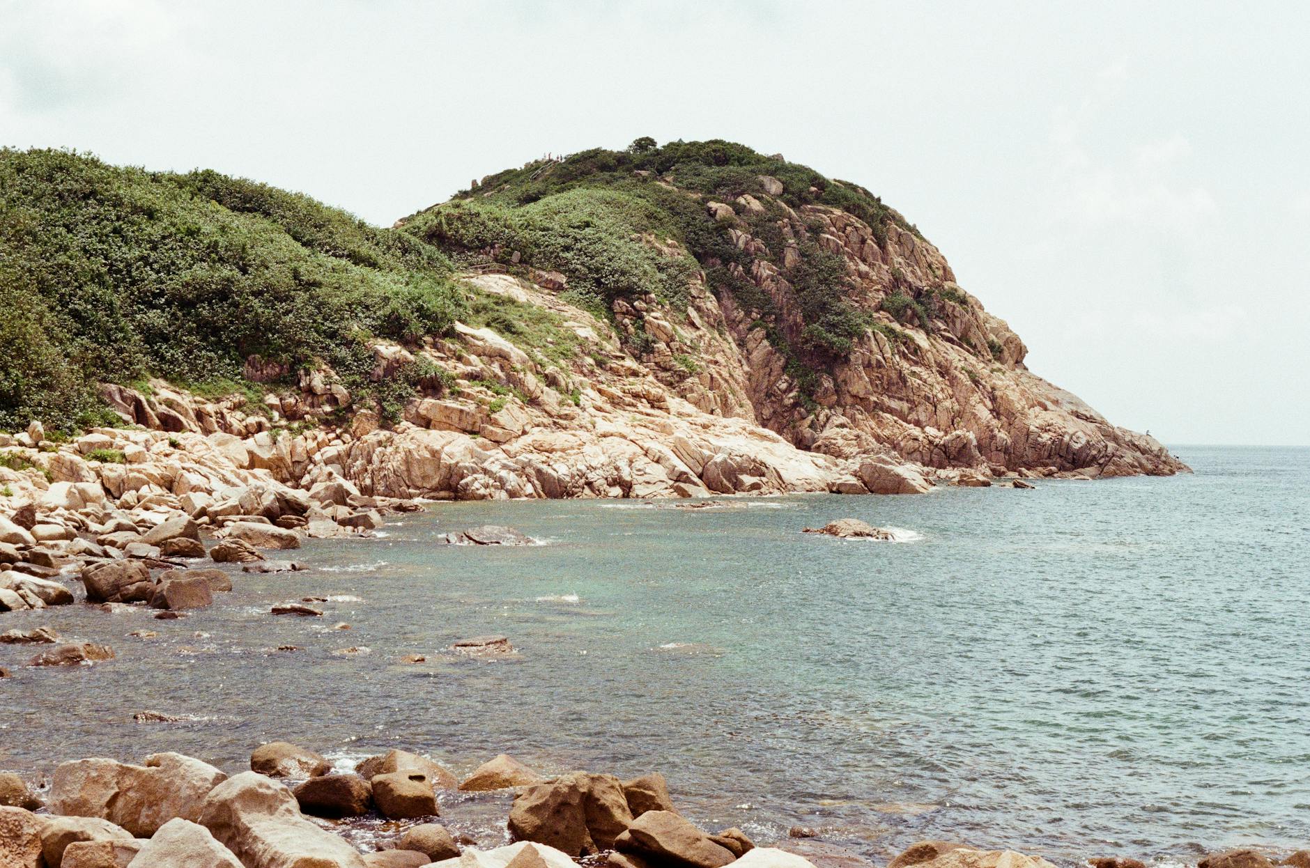 Skaliste wybrzeże i bujna zieleń na wyspie Hongkong nad morzem