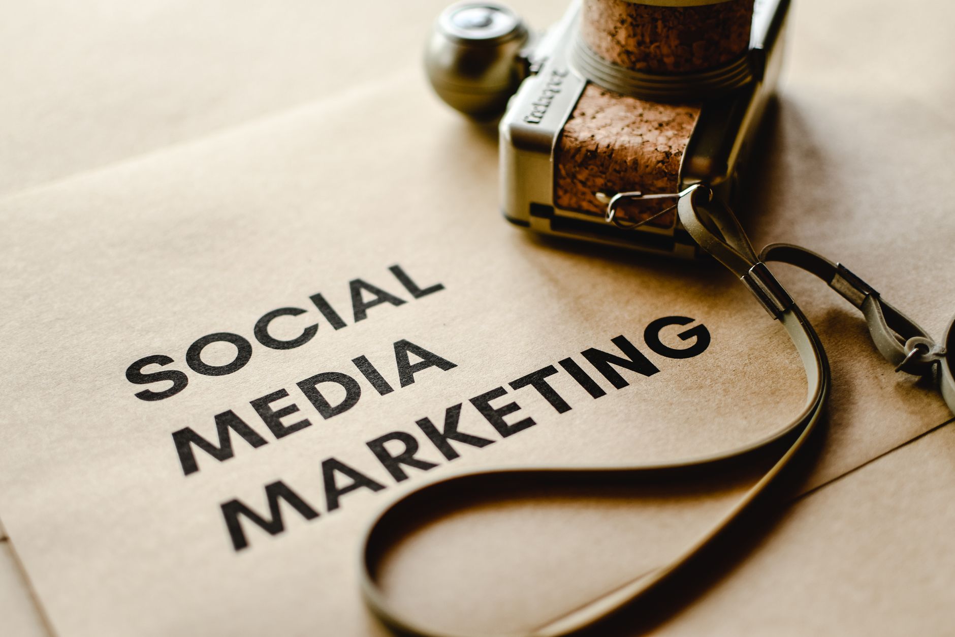 Aparat fotograficzny na brązowym papierze z napisem Social Media Marketing