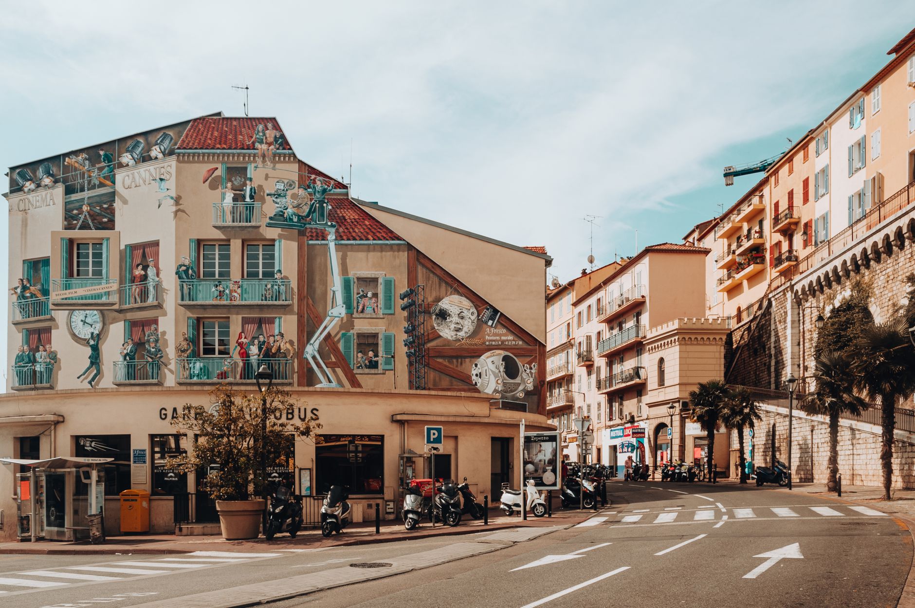 Kolorowy mural na budynku w Cannes ukazujący miejskie życie uliczne