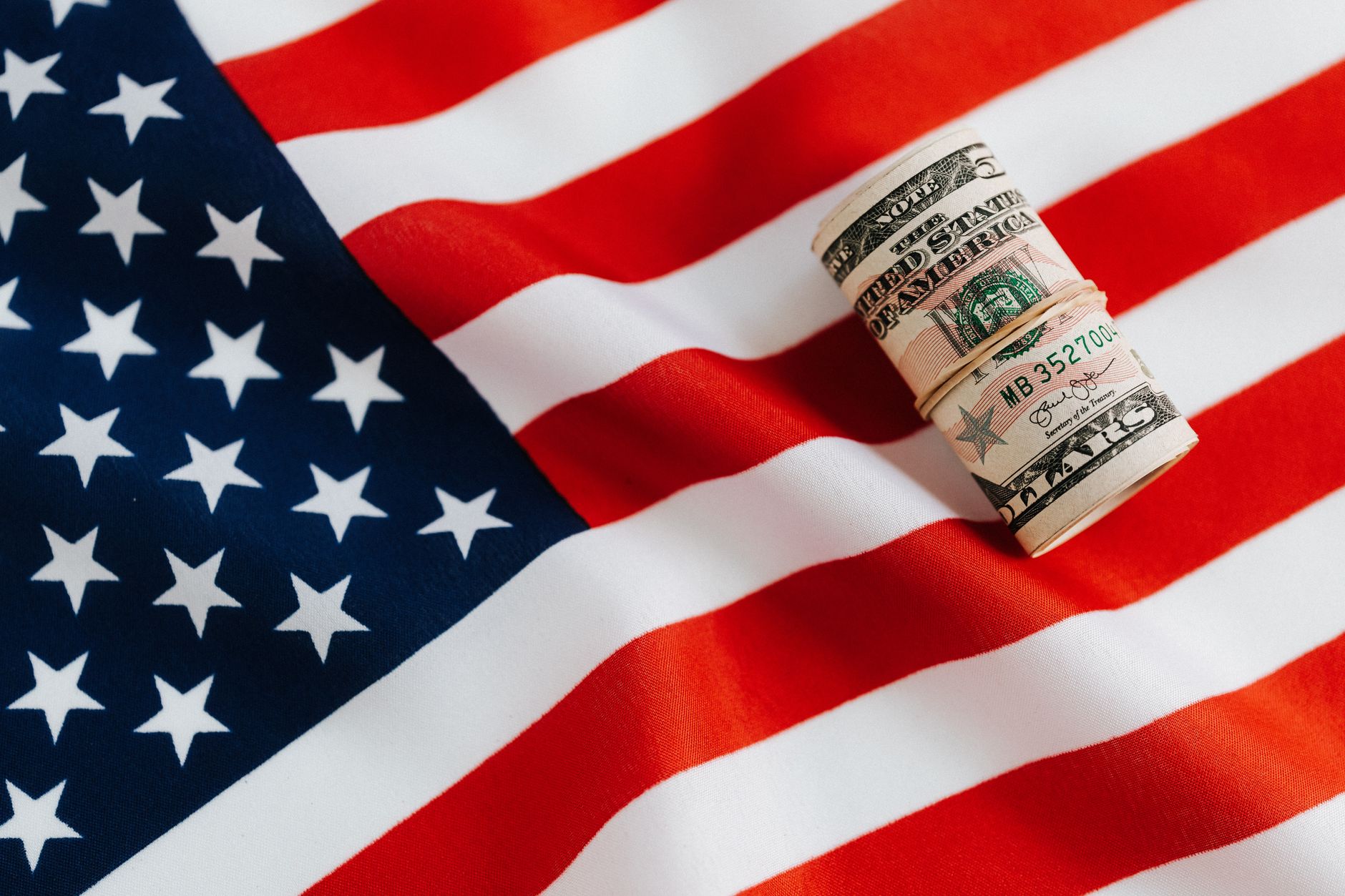 Zwitek dolarów na fladze USA, symbol oszczędnego zwiedzania USA