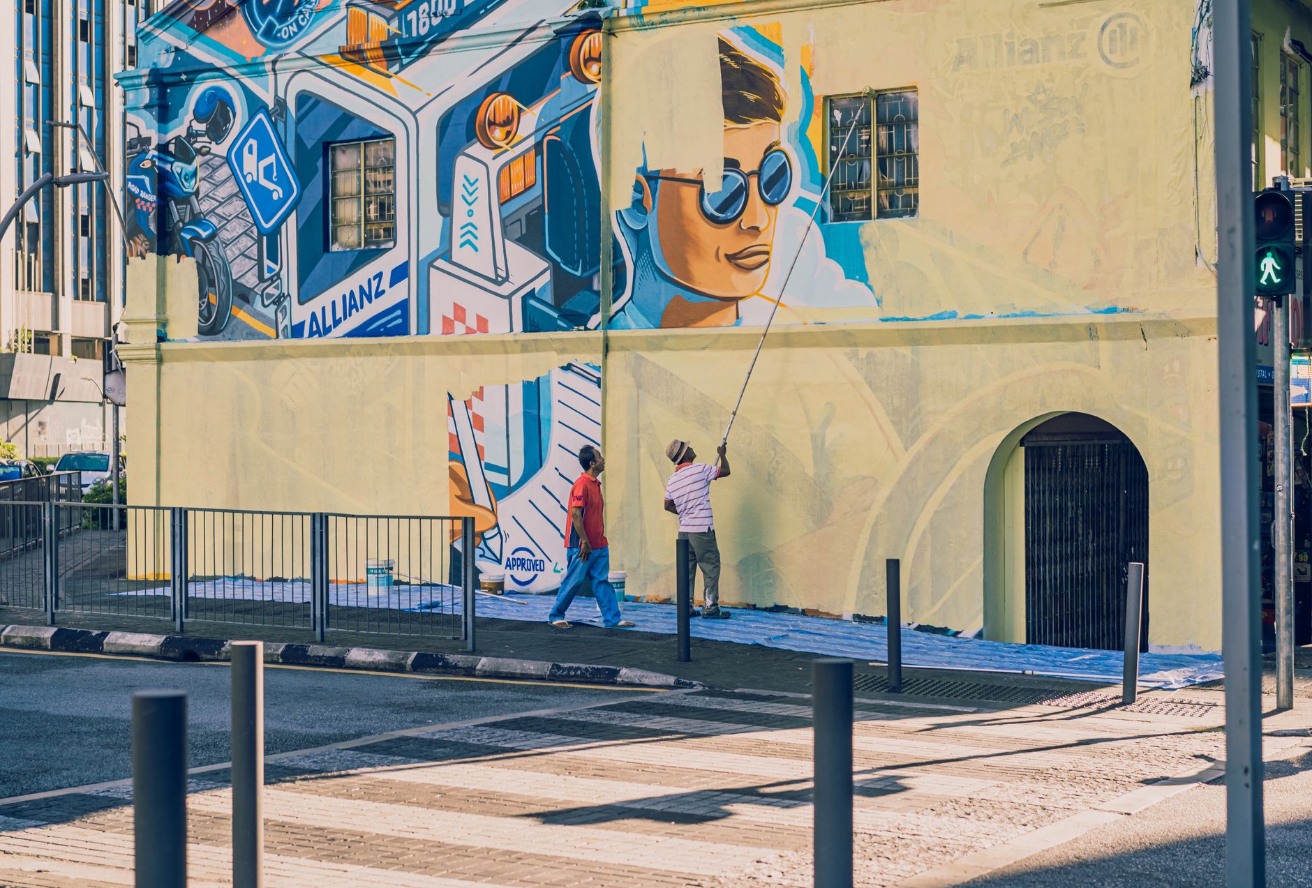 Artyści malują kolorowy mural na miejskim budynku w Kuala Lumpur