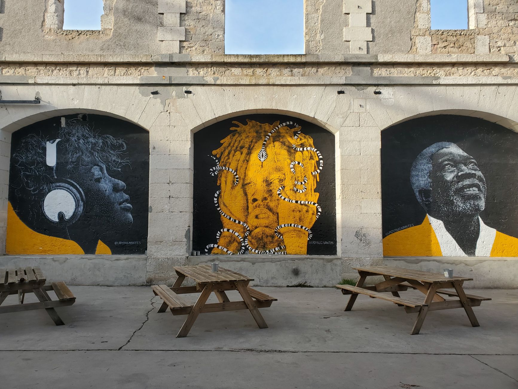 Kolorowe murale na kamiennym murze i drewniane ławki w Tajlandii